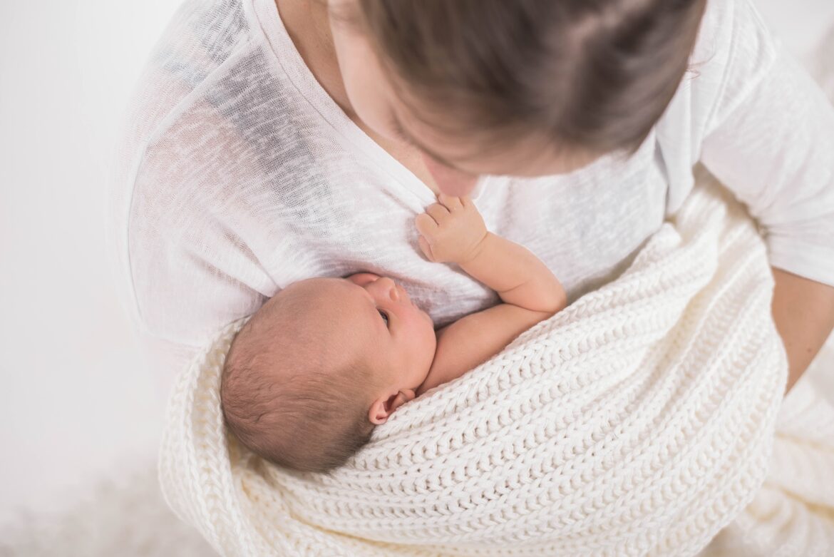 Mutter kuschelt mit Neugeborenem
